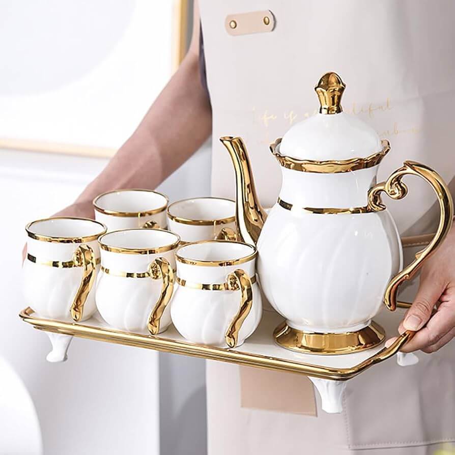 A beautifully crafted porcelain tea pot with a matching cup.