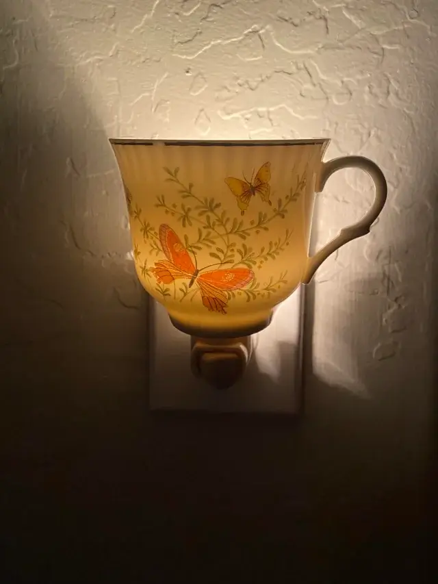 A single teacup illuminated in a dark workshop.