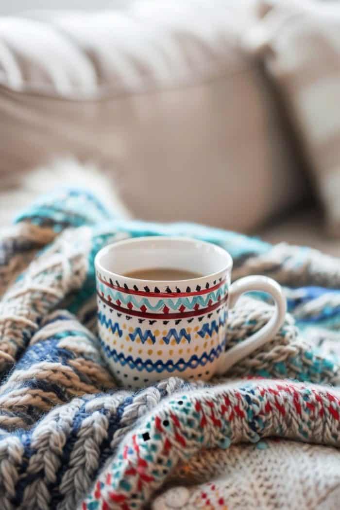 An artisan carefully painting a pattern on a ceramic cup.