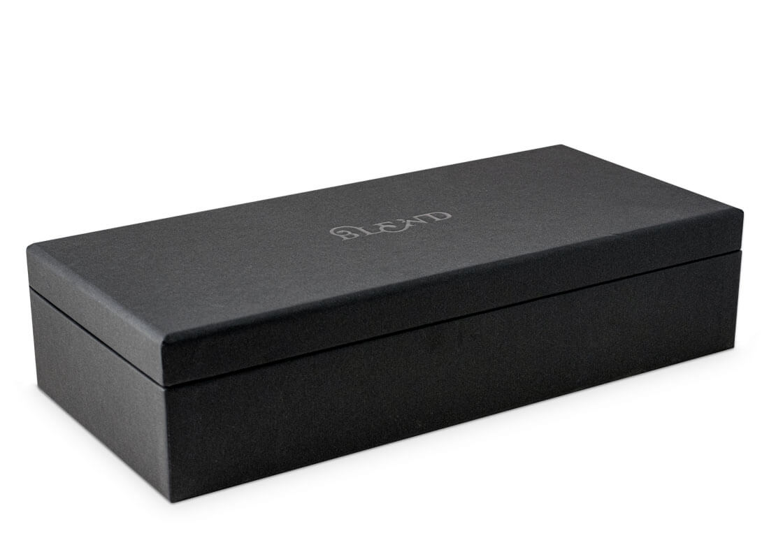 A finished tea set being carefully placed into a luxurious gift box.