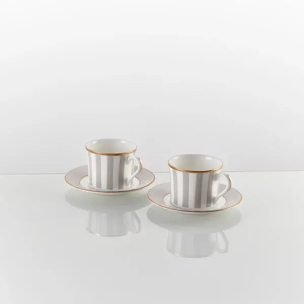 A tea set with a subtle, engraved company logo on the saucer.